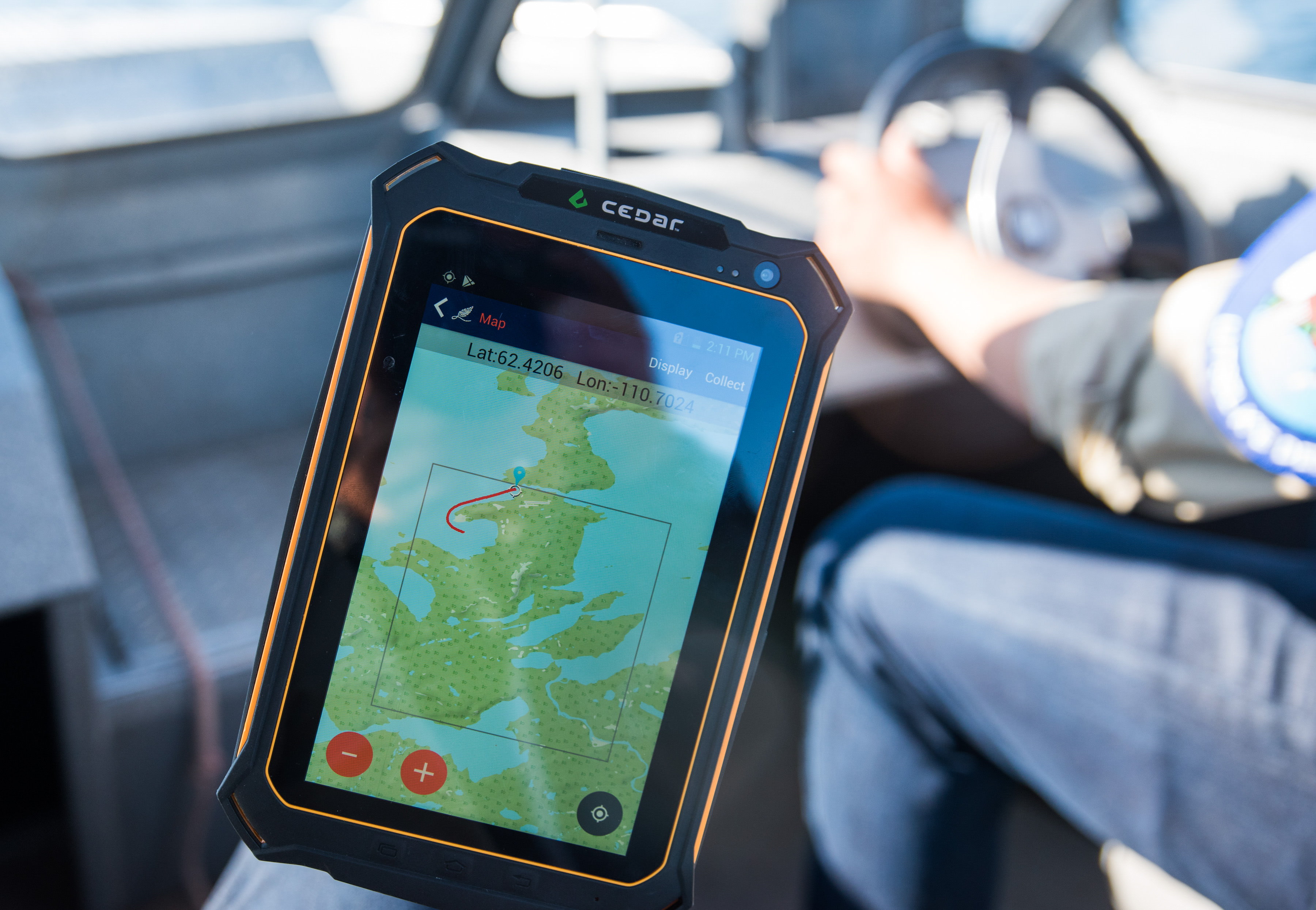 a handheld tablet shows a map used by indigenous guardians on a boat